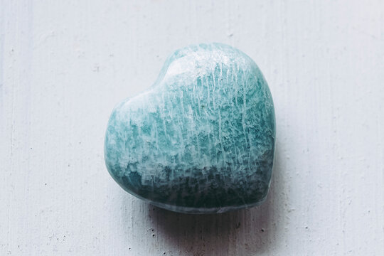 Pierre polie amazonite en forme de coeur sur un fond blanc - Min&eacute;ral naturel