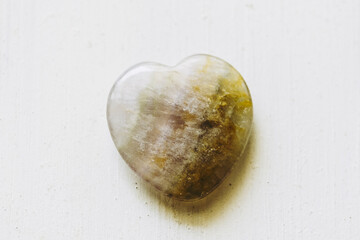 Pierre polie fluorite en forme de coeur sur un fond blanc - Minéral naturel