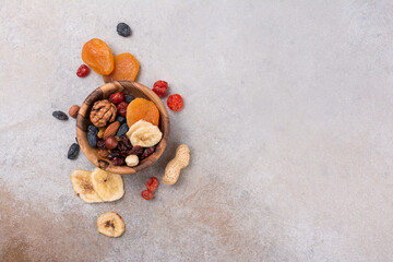 Wooden bowl with raisins, nuts and other dried fruit, berries as ingredient for tasty dessert