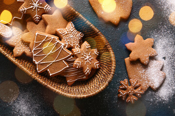 Wicker basket with sweet Christmas gingerbread cookies on black background