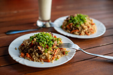 pilaf in a plate on wooden background, top view, cafe, copy space