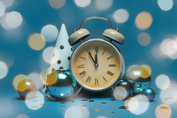 Alarm clock, party hat and decorations on blue background. Christmas countdown concept