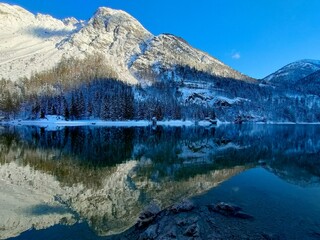 snow covered mountains and reflection in Lake Predil on the Julian Alps in winter