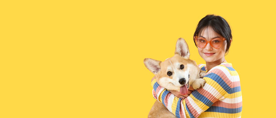 Woman and cute corgi dog on yellow background with space for text