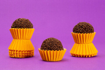 Brigadeiros, tradicional Brazilian sweet, on purple background, yellow packaging