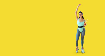 Beautiful young woman on roller skates and with cocktail against yellow background with space for text
