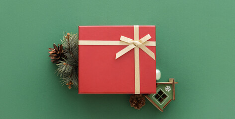 Christmas gift box and fir branch on green background