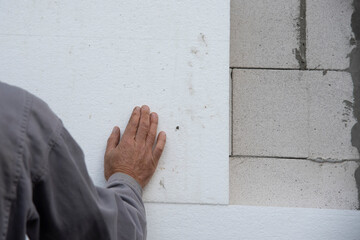 thermal insulation house. Construction worker installing styrofoam insulation sheets on house...