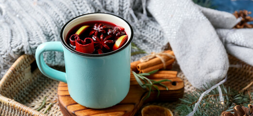 Mug of tasty mulled wine on table, closeup