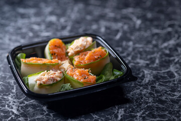 set of sushi rolls with seafood on a black stone background