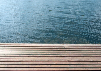 Closeup view of wooden pier near calm blue water