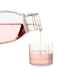 Pouring of cough syrup from bottle into cup on white background