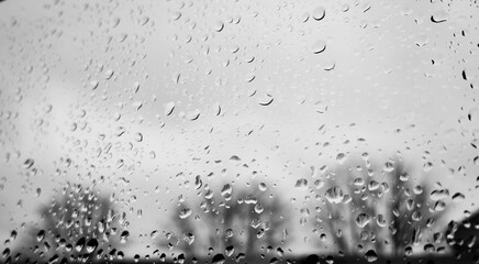 Grey autumn rainy day outside with rain drops  on the window glass