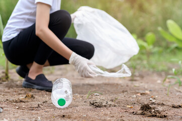 woman is collecting recycling junk on ground , ecological sustainable concept .