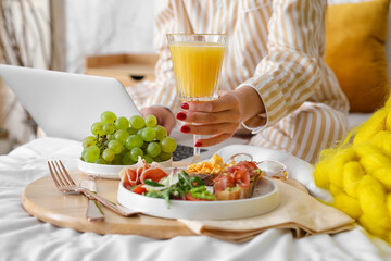 Woman having delicious breakfast in bed