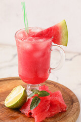 Wooden board with glass of cold watermelon fresh on light background, closeup