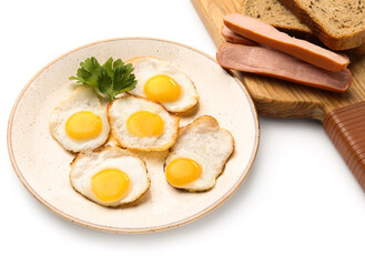 Plate with fried quail eggs and sausages on white background, closeup