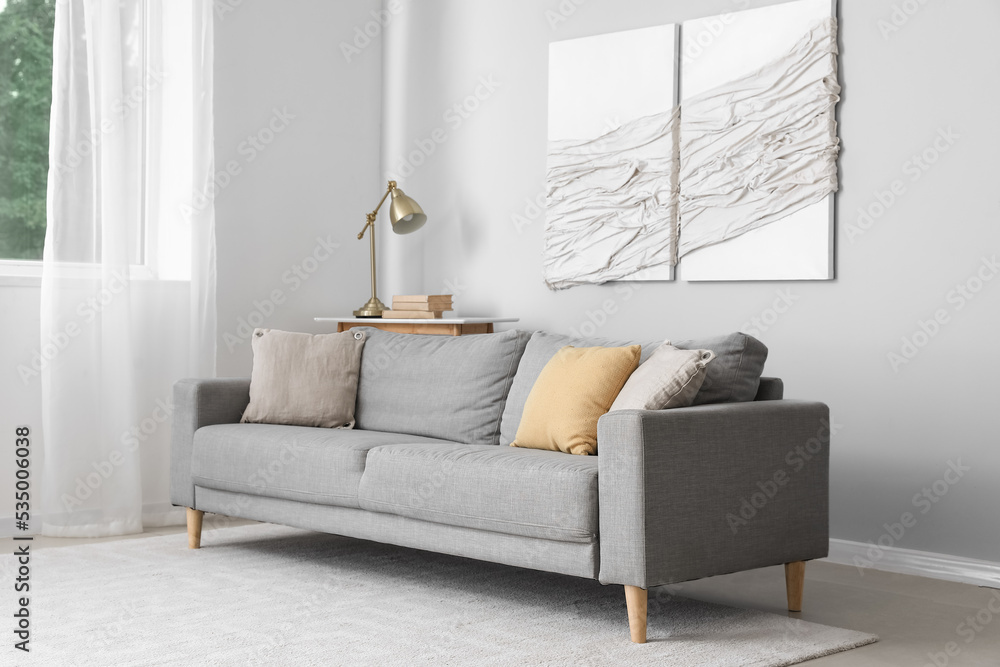 Wall mural interior of modern living room with grey sofa and 3d textile artwork