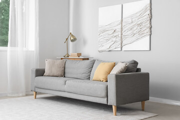 Interior of modern living room with grey sofa and 3D textile artwork