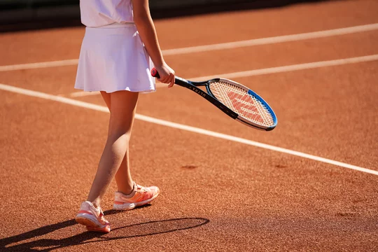 Young girl tennis player on a clay tennis court during a championship match  with a Wilson brand racket and ball. Tennis as a hobby sport for young  children. Romania, 2022. Photos | Adobe Stock