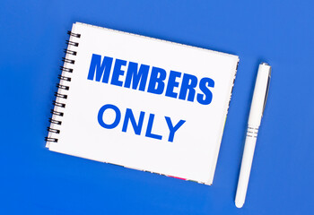 On a blue background, a white ballpoint pen and a white notepad with the text MEMBERS ONLY. View...