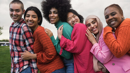 Happy young multi ethnic women having fun together in a public park - Diversity and friendship concept