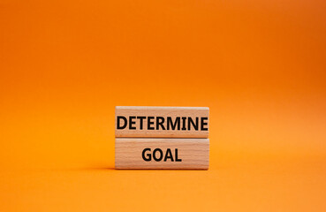 Determine goal symbol. Wooden blocks with words Determine goal. Beautiful orange background. Business and Determine goal concept. Copy space.