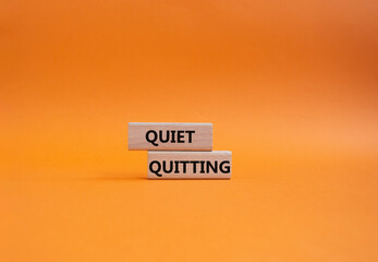 Quiet quitting symbol. Concept word Quiet quitting on wooden blocks. Beautiful orange background....