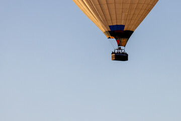 Part of hot air ballon with basket and people silhouettes. Copy space for text, clean background