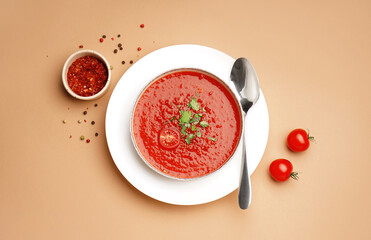 Bowl of tasty tomato soup and spices on color background