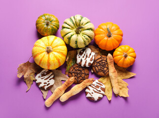 Halloween cookies with fallen leaves and pumpkins on violet background