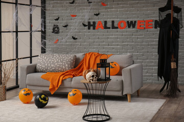 Interior of living room decorated for Halloween with grey sofa and balloons