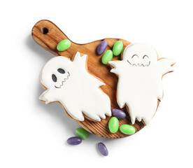 Board with Halloween ghost cookies and candies on white background