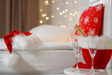 Two glasses and a bottle of champagne in a hotel room with Christmas decor. The concept of...