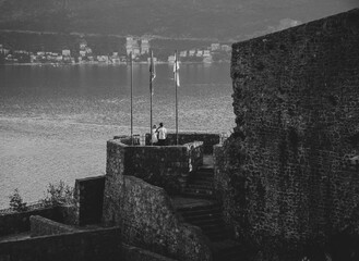 A young woman and man on the fortress next to the sea.