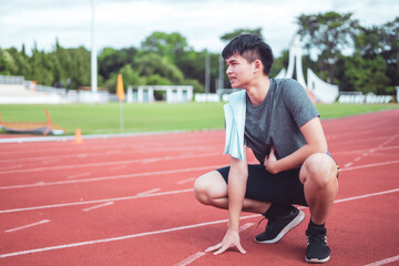 Exhausted man resting after jogging in the stadium during day.