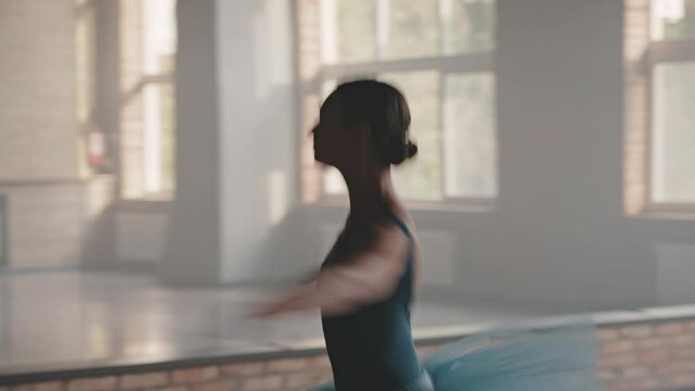 Elegant woman in dress spins around in choreography studio
