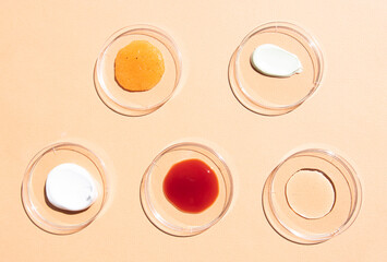 Beauty background with samples of cosmetics, flat lay. Face mask, body cream hyaluronic acid, scrub, lotion in glass containers, top view.