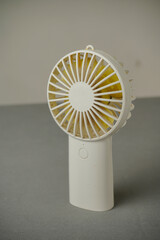 The handheld fan is white. Portable mini fan. Practically carried anywhere. © amirhamzaaa