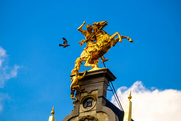 Dynamic statue on a house at the Grote Markt in Antwerp. A pigeon seemingly attacks a knight.