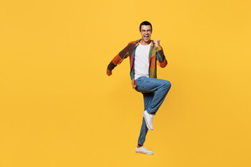 Fototapeta na wymiar Full body young fun middle eastern man 20s wear casual shirt white t-shirt doing winner gesture celebrate clenching fists say yes isolated on plain yellow background studio People lifestyle concept