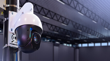 Warehouse video surveillance system. Camera inside warehouse building. Dome camera hanging on pole....