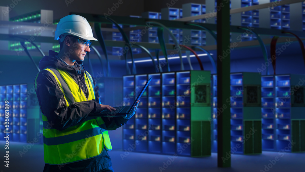 Poster employee large data center. data center man engineer in yellow vest. inspector with laptop in room w