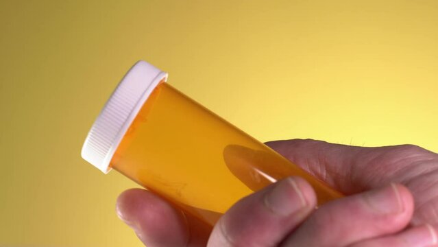 Holding And Looking At Perscription Pill Bottle