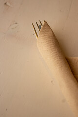 fork wrapped in napkin on a wooden top