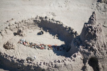 Sand castle with pebbles. castle with a tower