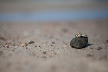 wedding rings on a stone on the shore of the Baltic sea