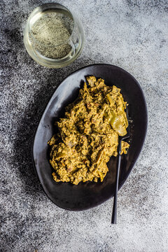 Overhead view of a bowl of traditional Georgian lobio with walnuts and a glass of white wine