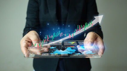 Woman showing holographic candlestick growth for stock, gold or cryptocurrency investing.