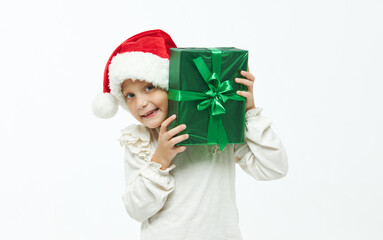 Christmas child. Cute toddler girl in santa claus caps holding colorful gift boxes on white. Wow fanny face. Preparing for New Year's holidays in Italy